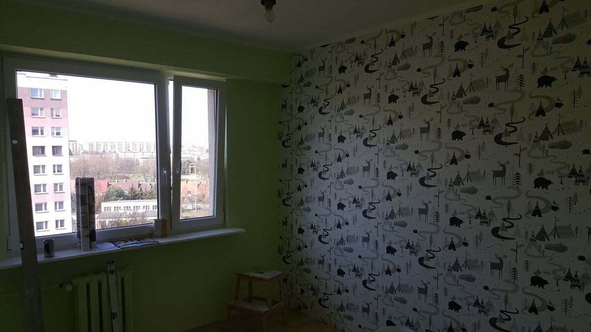 Ściana z fototapetą z motywem liści i kinkietem